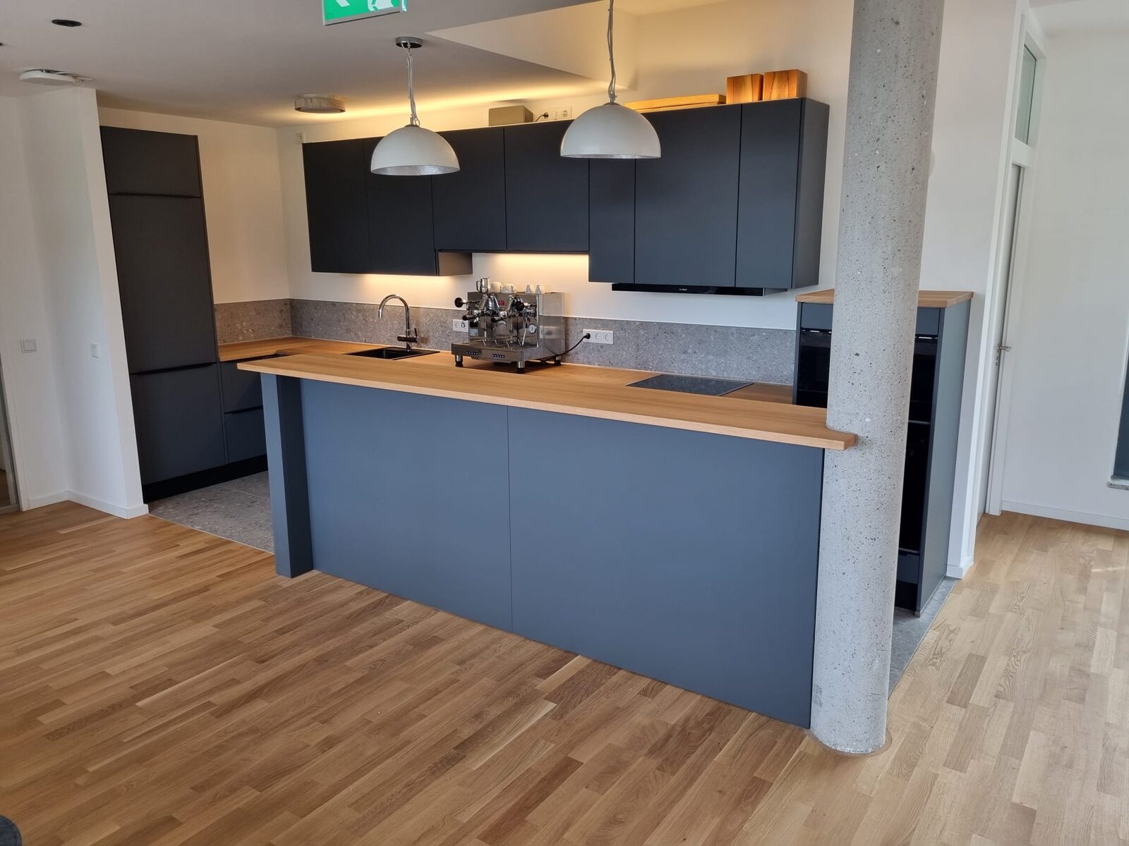 Dunkle Küche mit Theke und Holz-Arbeitsplatte