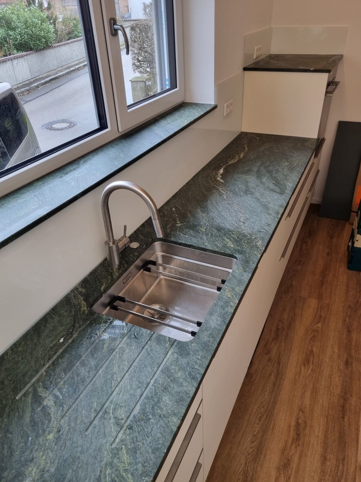 Grüne Natursteinplatte mit Unterbau-Spüle und Abtropfrillen