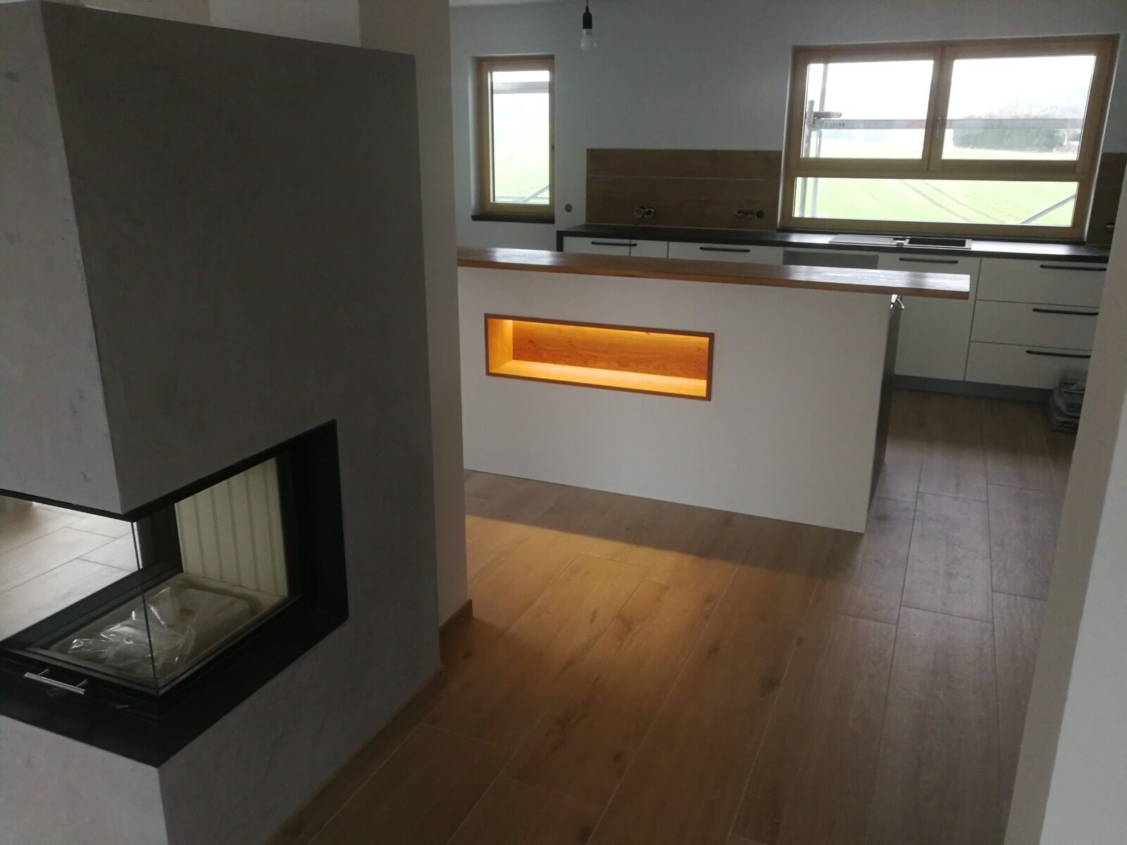 Offene Küche mit Tresen neben einem Kamin