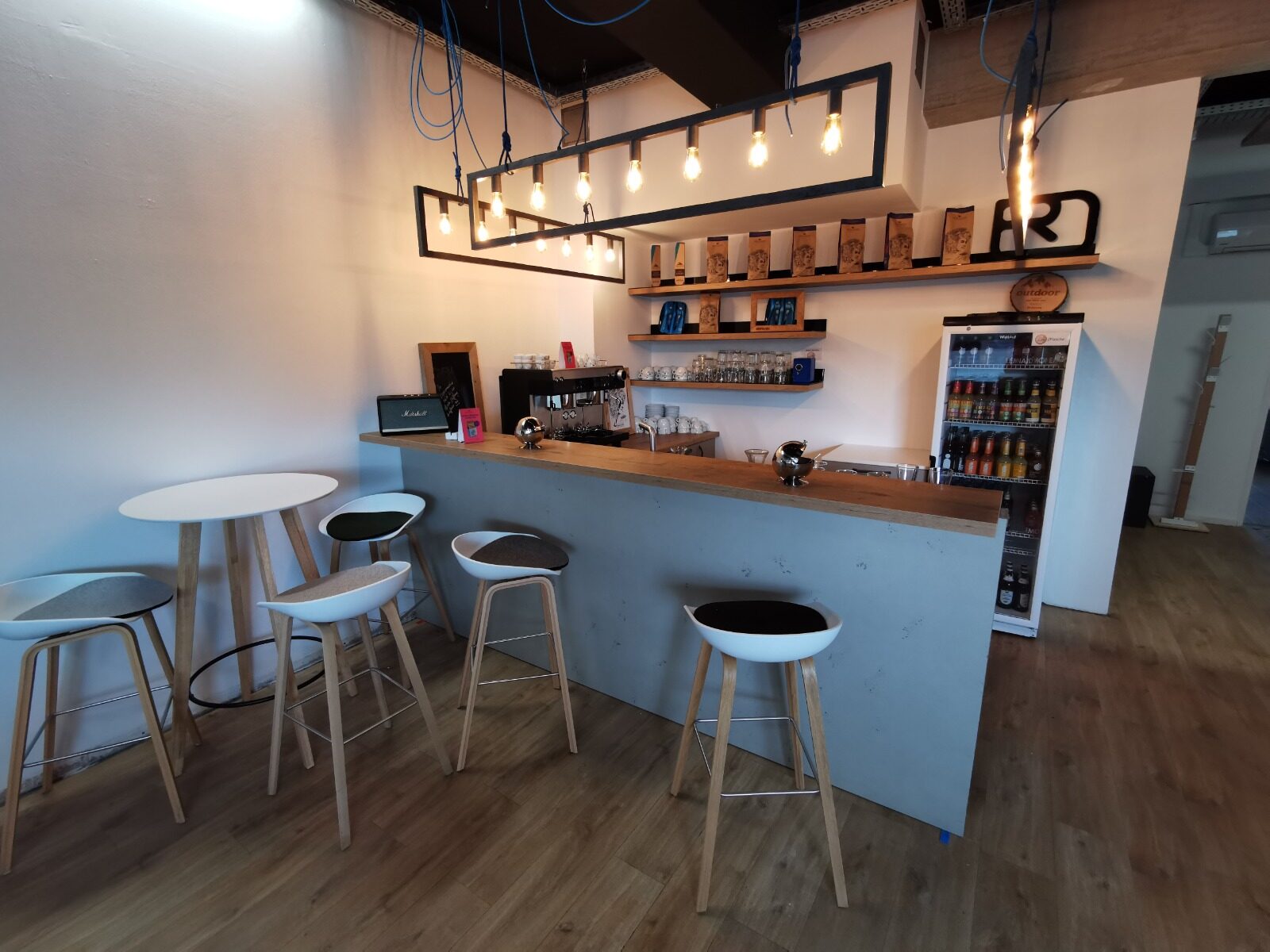Theke mit Siebträgermaschine und Barhockern