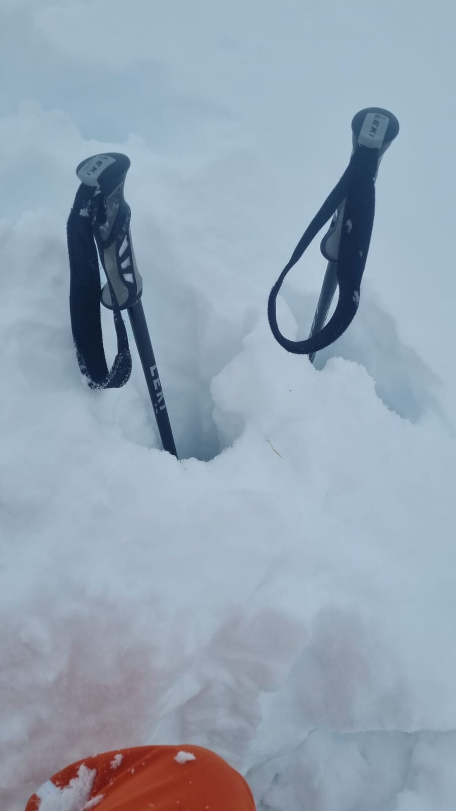 Zwei Skistöcke stecken im Tiefschnee